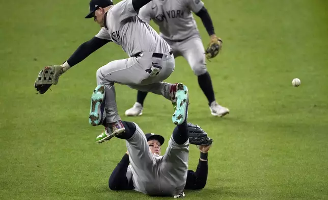 New York Yankees left fielder Alex Verdugo, top, leaps over center fielder Aaron Judge as Judge tries to catch a fly ball by Cleveland Guardians' David Fry during the fifth inning in Game 5 of the baseball AL Championship Series Saturday, Oct. 19, 2024, in Cleveland. (AP Photo/Jeff Roberson)