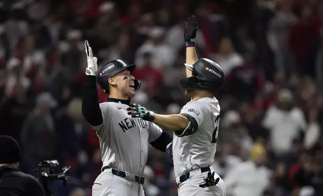 New York Yankees' Giancarlo Stanton, right, celebrates with Aaron Judge after hitting three-run home run against the Cleveland Guardians during the sixth inning in Game 4 of the baseball AL Championship Series Friday, Oct. 18, 2024, in Cleveland. (AP Photo/Godofredo A. Vásquez)