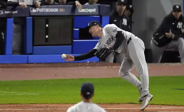 New York Yankees pitcher Mark Leiter Jr. makes an errant throw to first after fielding an infield hit by Cleveland Guardians' David Fry during the eighth inning in Game 4 of the baseball AL Championship Series Friday, Oct. 18, 2024, in Cleveland. (AP Photo/Jeff Roberson)