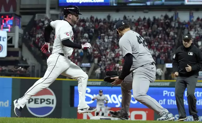 Cleveland Guardians' David Fry, left, is safe at first as New York Yankees first baseman Anthony Rizzo looks back for a errant throw from pitcher Mark Leiter Jr. during the eighth inning in Game 4 of the baseball AL Championship Series Friday, Oct. 18, 2024, in Cleveland. (AP Photo/Godofredo A. Vasquez)