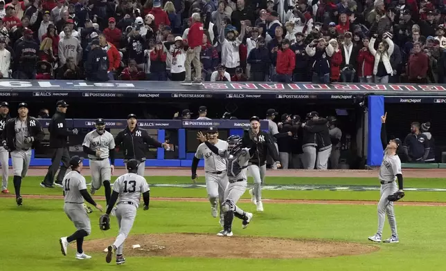 New York Yankees players celebrate after Game 5 of the baseball AL Championship Series against the Cleveland Guardians Saturday, Oct. 19, 2024, in Cleveland. The Yankees won 5-2 to advance to the World Series. (AP Photo/Jeff Roberson)