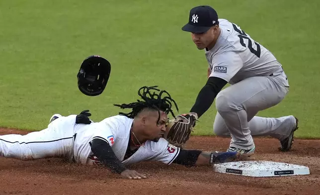 Cleveland Guardians' José Ramírez, right, steals second base as New York Yankees second baseman Gleyber Torres (25) reaches to tag him during the third inning in Game 3 of the baseball AL Championship Series Thursday, Oct. 17, 2024, in Cleveland.(AP Photo/Sue Ogrocki)