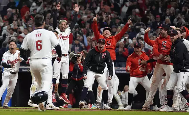 Cleveland Guardians players wait for David Fry (6) to cross home plate after hitting a game-winning two-run home run against the New York Yankees during the 10th inning in Game 3 of the baseball AL Championship Series Thursday, Oct. 17, 2024, in Cleveland. The Guardians won 7-5. (AP Photo/Jeff Roberson)