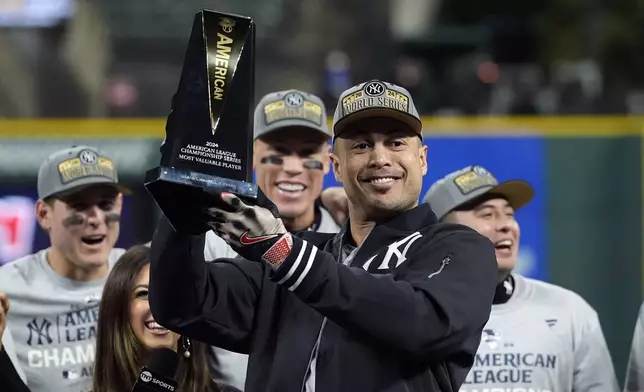 New York Yankees' Giancarlo Stanton holds up the MVP trophy after Game 5 of the baseball AL Championship Series Sunday, Oct. 20, 2024, in Cleveland. The Yankees won 5-2 to advance to the World Series. (AP Photo/Godofredo A. Vásquez )