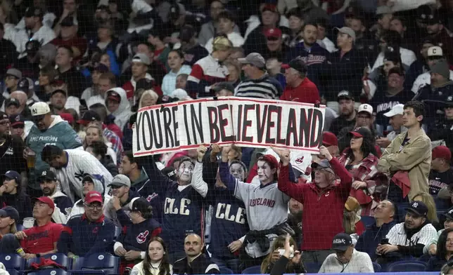 Fans hold up a sign during the second inning in Game 5 of the baseball AL Championship Series between the New York Yankees and Cleveland Guardians Saturday, Oct. 19, 2024, in Cleveland. (AP Photo/Sue Ogrocki)