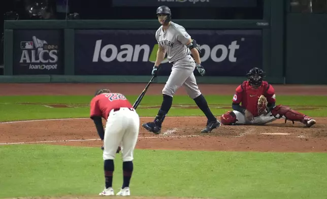 New York Yankees' Giancarlo Stanton, center, watches his two-run home run off Cleveland Guardians starting pitcher Tanner Bibee (28) during the sixth inning in Game 5 of the baseball AL Championship Series Saturday, Oct. 19, 2024, in Cleveland. (AP Photo/Jeff Roberson)