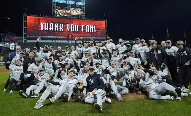 The New York Yankees pose for a team picture after Game 5 of the baseball AL Championship Series against the Cleveland Guardians Saturday, Oct. 19, 2024, in Cleveland. The Yankees won 5-2 to advance to the World Series. (AP Photo/Godofredo A. Vásquez )