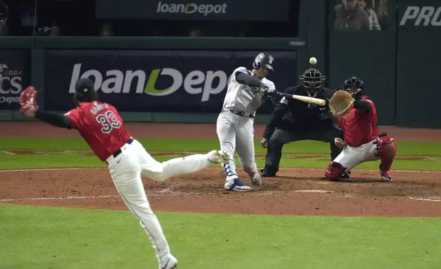 New York Yankees' Juan Soto hits a three-run home run off Cleveland Guardians pitcher Hunter Gaddis (33) during the 10th inning in Game 5 of the baseball AL Championship Series Saturday, Oct. 19, 2024, in Cleveland. (AP Photo/Jeff Roberson)