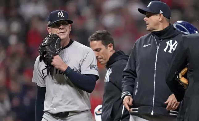 New York Yankees relief pitcher Ian Hamilton, left, leaves the game during the sixth inning in Game 3 of the baseball AL Championship Series against the Cleveland GuardiansvThursday, Oct. 17, 2024, in Cleveland.(AP Photo/Godofredo Vásquez )