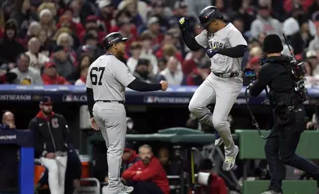 New York Yankees' Juan Soto, right, celebrates with third base coach Luis Rojas (67) after hitting a two-run home run against the Cleveland Guardians during the first inning in Game 4 of the baseball AL Championship Series Friday, Oct. 18, 2024, in Cleveland. (AP Photo/Godofredo A. Vásquez)