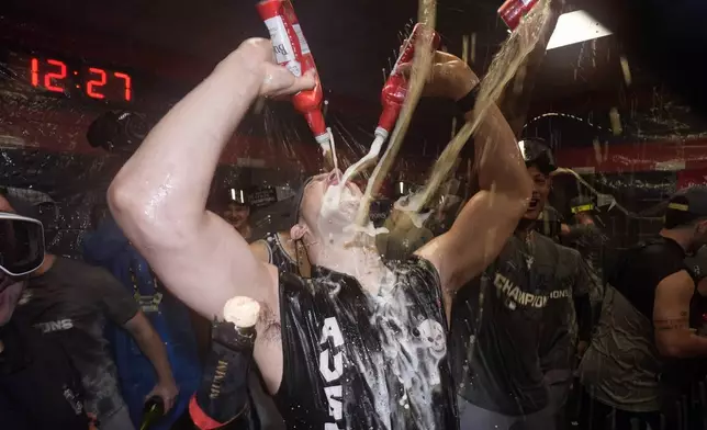 New York Yankees' Tommy Kahnle celebrates in the clubhouse after Game 5 of the baseball AL Championship Series against the Cleveland Guardians Sunday, Oct. 20, 2024, in Cleveland. The Yankees won 5-2 to advance to the World Series. (AP Photo/Godofredo A. Vásquez )