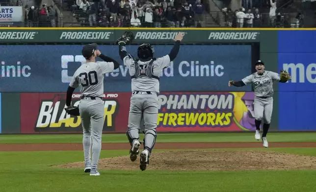 New York Yankees' Luke Weaver (30), Jose Trevino (39) and Anthony Volpe celebrate after Game 5 of the baseball AL Championship Series against the Cleveland Guardians Saturday, Oct. 19, 2024, in Cleveland. The Yankees won 5-2 to advance to the World Series. (AP Photo/Godofredo A. Vásquez )