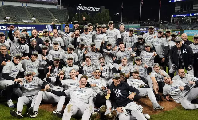 New York Yankees players pose for a team picture after Game 5 of the baseball AL Championship Series against the Cleveland Guardians Saturday, Oct. 19, 2024, in Cleveland. The Yankees won 5-2 to advance to the World Series. (AP Photo/Sue Ogrocki)