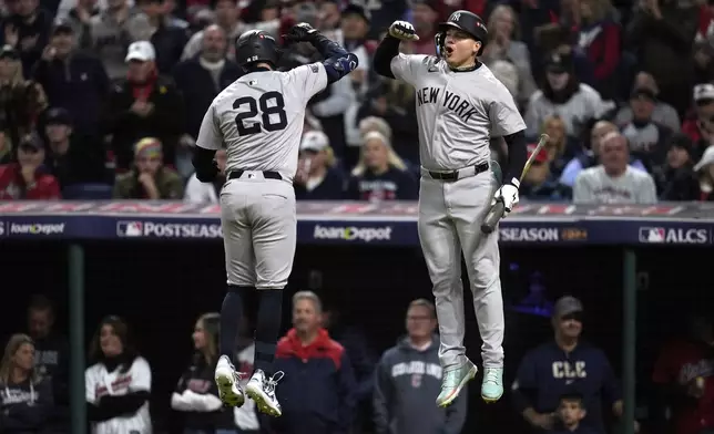 New York Yankees' Austin Wells (28) celebrates with Alex Verdugo after hitting a home run against the Cleveland Guardians during the second inning in Game 4 of the baseball AL Championship Series Friday, Oct. 18, 2024, in Cleveland. (AP Photo/Sue Ogrocki)