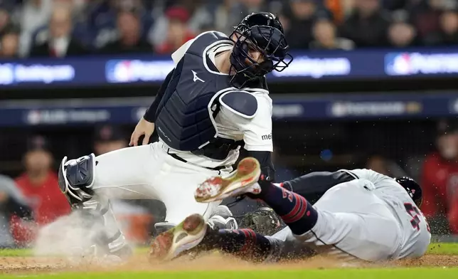 Cleveland Guardians' Brayan Rocchio, right, scores in front of Detroit Tigers catcher Jake Rogers, left, on a bunt by David Fry in the eighth inning of Game 4 of a baseball American League Division Series, Thursday, Oct. 10, 2024, in Detroit. (AP Photo/Carlos Osorio)