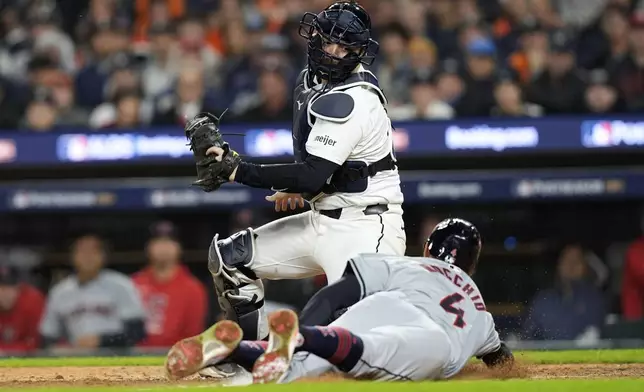 Cleveland Guardians' Brayan Rocchio, right, scores in front of Detroit Tigers catcher Jake Rogers, left, on a bunt by David Fry in the eighth inning of Game 4 of a baseball American League Division Series, Thursday, Oct. 10, 2024, in Detroit. (AP Photo/Carlos Osorio)