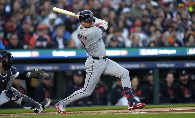 Cleveland Guardians' Lane Thomas hits an RBI single to score teammate Steven Kwan in the first inning during Game 4 of a baseball American League Division Series against the Detroit Tigers, Thursday, Oct. 10, 2024, in Detroit. (AP Photo/Paul Sancya)