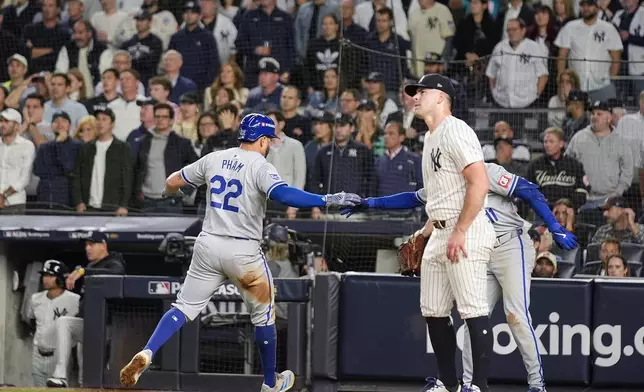 Kansas City Royals' Tommy Pham (22) scores as New York Yankees pitcher Carlos Rodón looks on during the fourth inning of Game 2 of the American League baseball playoff series, Monday, Oct. 7, 2024, in New York. (AP Photo/Seth Wenig)