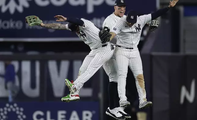 New York Yankees left fielder Alex Verdugo, left, center fielder Aaron Judge, center, and Juan Soto celebrate after beating the Kansas City Royals in Game 1 of the American League baseball division series, Saturday, Oct. 5, 2024, in New York. (AP Photo/Adam Hunger)