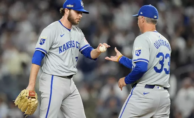 Kansas City Royals pitcher Sam Long (73) hands the ball to Kansas City Royals manager Matt Quatraro (33) as he leaves the game during the sixth inning of Game 1 of the American League baseball division series against the New York Yankees, Saturday, Oct. 5, 2024, in New York. (AP Photo/Frank Franklin II)