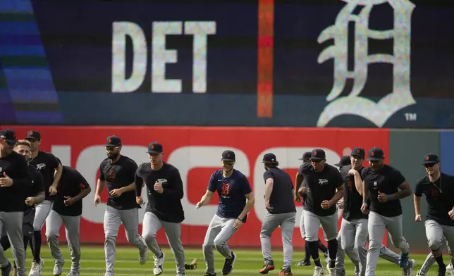 The Detroit Tigers run in from the outfield during a baseball workout in Cleveland, Friday, Oct. 4, 2024, in preparation for the American League Division Series against the Cleveland Guardians. (AP Photo/Sue Ogrocki)