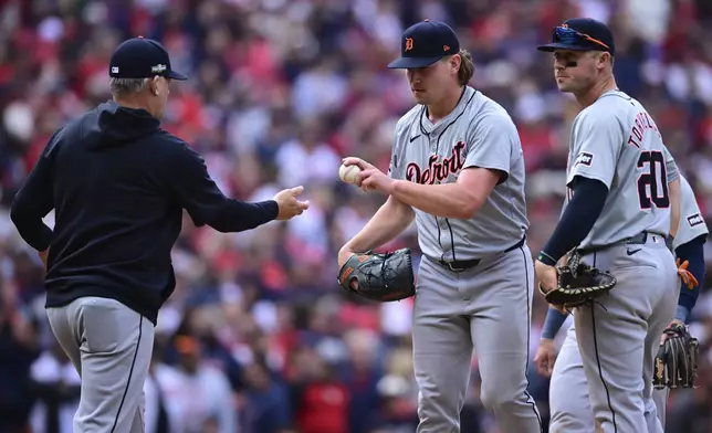 Detroit Tigers manager A.J. Hinch, left, takes relief pitcher Tyler Holton, center, out of the game as Spencer Torkelson (20) looks on in the eighth inning during Game 5 of baseball's American League Division Series against the Cleveland Guardians, Saturday, Oct. 12, 2024, in Cleveland. (AP Photo/David Dermer)