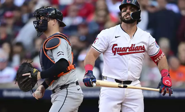 Cleveland Guardians' Austin Hedges, right, reacts after striking out in the third inning during Game 2 of baseball's AL Division Series against the Detroit Tigers, Monday, Oct. 7, 2024, in Cleveland. Tigers catcher Jake Rogers is at left. (AP Photo/David Dermer)