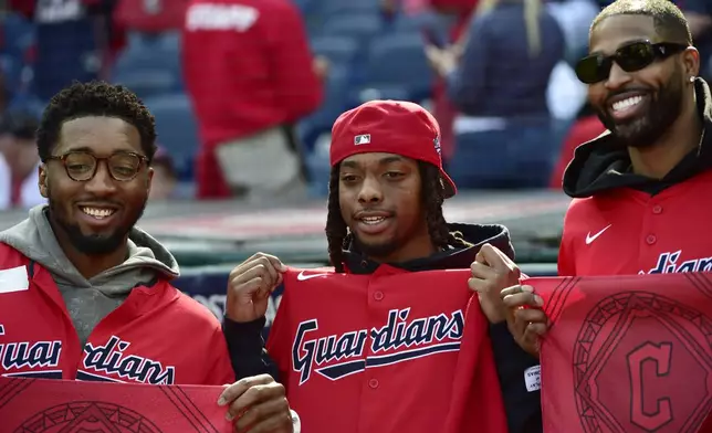 Cleveland Cavaliers players, from left, Donovan Mitchell, Darius Garland and Tristan Thompson pose before Game 5 in baseball's American League Division Series between the Detroit Tigers and the Cleveland Guardians, Saturday, Oct. 12, 2024, in Cleveland. (AP Photo/Phil Long)