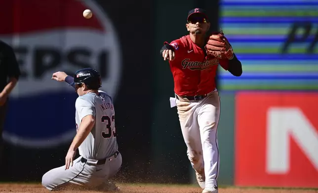 Cleveland Guardians second baseman Andres Gimenez, right, throws the ball to first base after forcing out Detroit Tigers' Colt Keith (33) at second base on a double play ball hit by Spencer Torkelson in the fourth inning during Game 1 of baseball's AL Division Series, Saturday, Oct. 5, 2024, in Cleveland. (AP Photo/David Dermer)