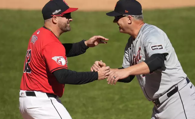 Cleveland Guardians manager Stephen Vogt, left, and Detroit Tigers manager A.J. Hinch, right, greet each other before Game 1 of baseball's American League Division Series against the Detroit Tigers, Saturday, Oct. 5, 2024, in Cleveland. (AP Photo/Sue Ogrocki)