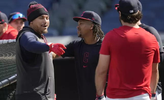 Cleveland Guardians' Josh Naylor, left, talks with teammates Jose Ramirez, center, and Austin Hedges, right, during a baseball workout in Cleveland, Friday, Oct. 4, 2024, in preparation for the American League Division Series against the Detroit Tigers. (AP Photo/Sue Ogrocki)