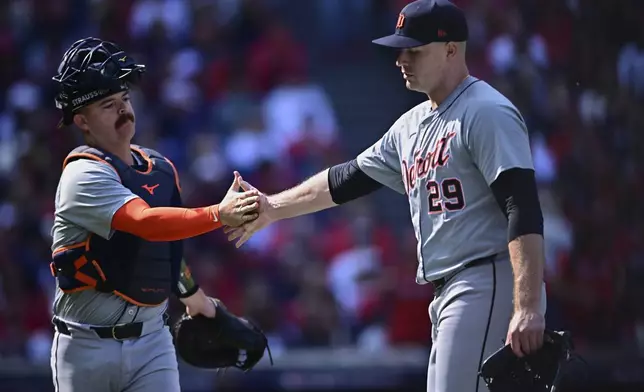 Detroit Tigers starting pitcher Tarik Skubal (29) is greeted by catcher Jake Rogers, left, as he walks off the mound during the first inning in Game 5 of baseball's American League Division Series against the Cleveland Guardians, Saturday, Oct. 12, 2024, in Cleveland. (AP Photo/David Dermer)