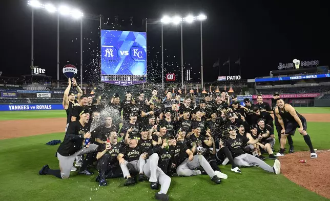 Members of the New York Yankees celebrate following a 3-1 victory over the Kansas City Royals in Game 4 of an American League Division baseball playoff series Thursday, Oct. 10, 2024, in Kansas City, Mo. (AP Photo/Reed Hoffmann)