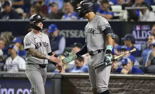 New York Yankees' Alex Verdugo, left, is congratulated by teammate Aaron Judge after scoring during the fifth inning in Game 4 of an American League Division baseball playoff series against the Kansas City Royals Thursday, Oct. 10, 2024, in Kansas City, Mo. (AP Photo/Reed Hoffmann)