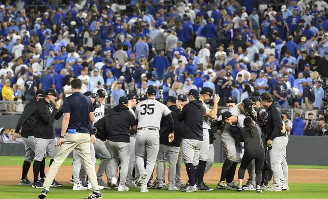 Members of the New York Yankees celebrate after defeating the Kansas City Royals 3-1 in Game 4 of an American League Division baseball playoff series and move on to the ALCS Thursday, Oct. 10, 2024, in Kansas City, Mo. (AP Photo/Reed Hoffmann)