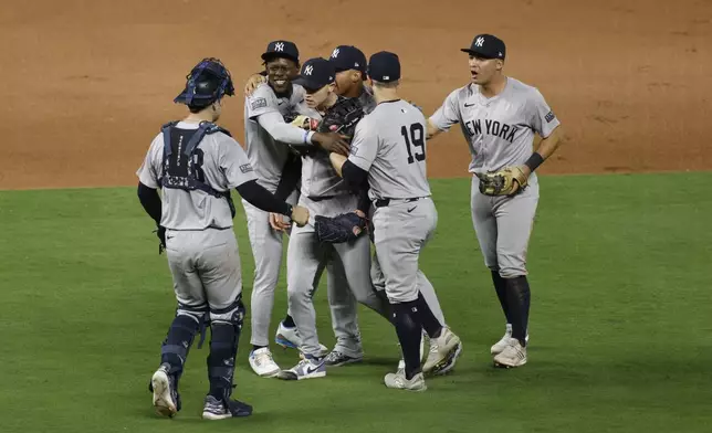 Members of the New York Yankees celebrate a 3-1 victory over the Kansas City Royals in Game 4 of an American League Division baseball playoff series Thursday, Oct. 10, 2024, in Kansas City, Mo. (AP Photo/Colin Braley)