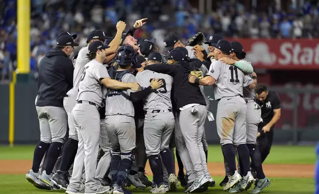 Members of the New York Yankees celebrate after defeating the Kansas City Royals 3-1 in Game 4 of an American League Division baseball playoff series and move on to the ALCS Thursday, Oct. 10, 2024, in Kansas City, Mo. (AP Photo/Charlie Riedel)