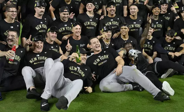 Members of the New York Yankees celebrate following a 3-1 victory over the Kansas City Royals in Game 4 of an American League Division baseball playoff series Thursday, Oct. 10, 2024, in Kansas City, Mo. (AP Photo/Reed Hoffmann)