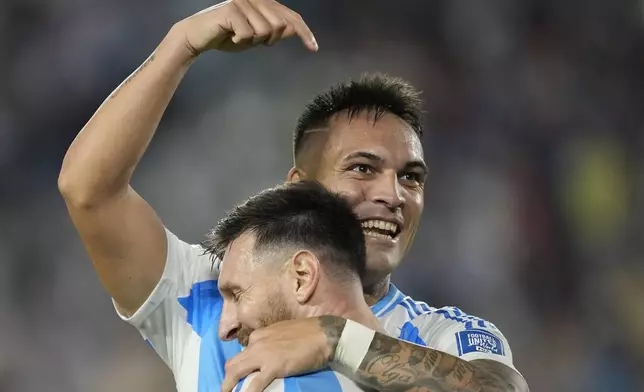 Argentina's Lautaro Martinez, celebrates with teammate Lionel Messi after scoring his side's 2nd goal against Bolivia during a World Cup 2026 qualifying soccer match at Monumental stadium in Buenos Aires, Argentina, Tuesday, Oct. 15, 2024. (AP Photo/Natacha Pisarenko)