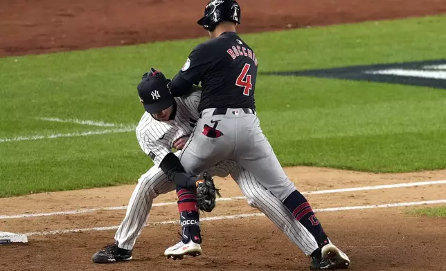 Cleveland Guardians' Brayan Rocchio (4) collides with New York Yankees relief pitcher Tim Hill during the eighth inning in Game 1 of the baseball AL Championship Series Monday, Oct. 14, 2024, in New York. (AP Photo/Seth Wenig)