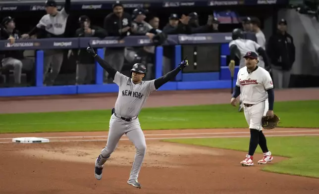 New York Yankees' Juan Soto, left, celebrates after hitting a two-run home run against the Cleveland Guardians during the first inning in Game 4 of the baseball AL Championship Series Friday, Oct. 18, 2024, in Cleveland. (AP Photo/Jeff Roberson)