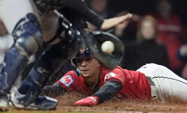 Cleveland Guardians' Andrés Giménez scores as New York Yankees catcher Austin Wells handles the throw at home plate during the fifth inning in Game 5 of the baseball AL Championship Series Saturday, Oct. 19, 2024, in Cleveland. (AP Photo/Godofredo A. Vásquez)