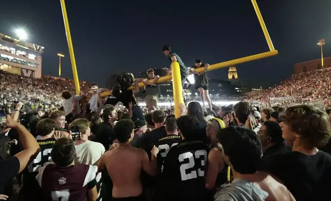 Vanderbilt fans tear down the goal post the after team's 40-35 win over No. 1 Alabama in an NCAA college football game Saturday, Oct. 5, 2024, in Nashville, Tenn. (AP Photo/George Walker IV)