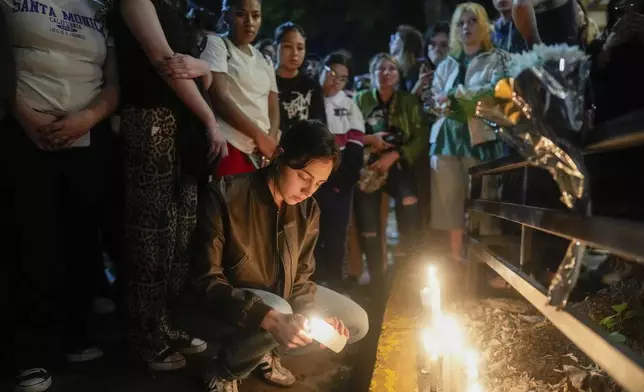 Fans light candles outside the hotel where former One Direction singer Liam Payne was found dead after he fell from a balcony in Buenos Aires, Argentina, Wednesday, Oct. 16, 2024. (AP Photo/Natacha Pisarenko)