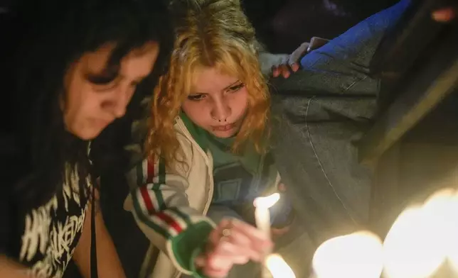 Fans light candles outside the hotel where former One Direction singer Liam Payne was found dead after he fell from a balcony in Buenos Aires, Argentina, Wednesday, Oct. 16, 2024. (AP Photo/Natacha Pisarenko)