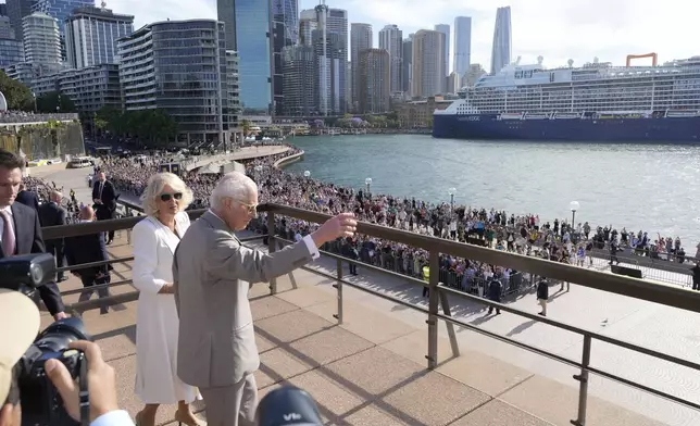 Britain's King Charles III, right, waves to the crowd beside Queen Camilla during their visit to the Sydney Opera House in Sydney, Australia, Tuesday, Oct. 22, 2024. (AP Photo/Mark Baker, Pool)