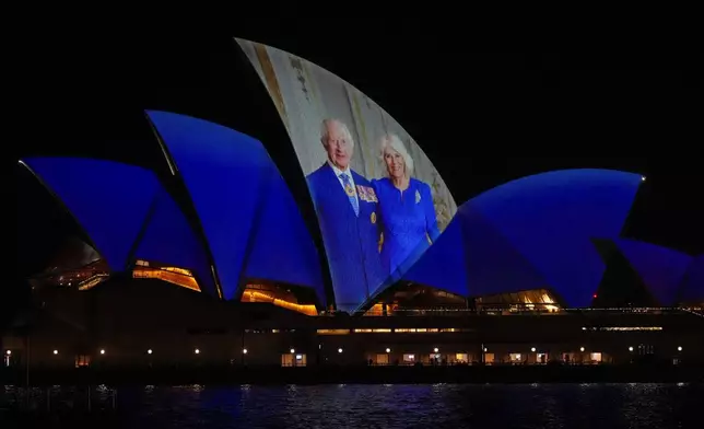 The Sydney Opera House sails show photos of Britain's King Charles and Queen camilla soon after their arrival in Sydney, Australia, Friday, Oct. 18, 2024. (AP Photo/Mark Baker)