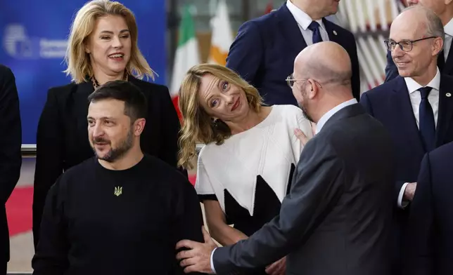 European Council President Charles Michel, second right, talks to Italy's Prime Minister Giorgia Meloni, center, next to Ukraine's President Volodymyr Zelenskyy, bottom left, as they arrive for a group photo during an EU summit in Brussels, Thursday, Oct. 17, 2024. (AP Photo/Geert Vanden Wijngaert)