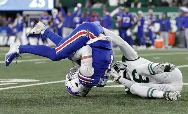 Buffalo Bills cornerback Taron Johnson, left, intercepts a pass intended for New York Jets wide receiver Mike Williams, right, during the second half of an NFL football game in East Rutherford, N.J., Monday, Oct. 14, 2024. (AP Photo/Adam Hunger)