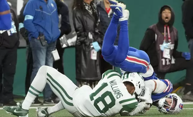 Buffalo Bills cornerback Taron Johnson, right, intercepts a pass intended for New York Jets wide receiver Mike Williams (18) during the second half of an NFL football game in East Rutherford, N.J., Monday, Oct. 14, 2024. (AP Photo/Pamela Smith)